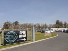 A parking lot with cars and a sign for Fairyglen Cafe and Bistro at Gleann na Siog in Gaoth Dobhair