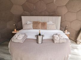 A bed with pillows robes and slippers and a bottle of champagne in an ice bucket at Number 2 Dome in Derrybeg County Donegal