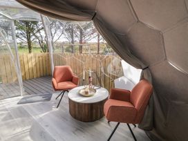 A seating area with two chairs and a round table inside a geodesic dome at Number 2 Dome in Derrybeg County Donegal