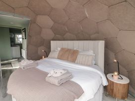 A bedroom with a bed towels and a nightstand with a lamp at Number 2 Dome in Derrybeg County Donegal