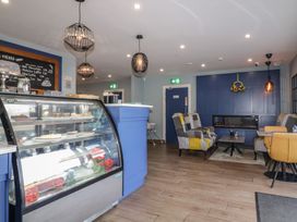 A cafe interior with a glass display case of pastries tables chairs and a fireplace at Number 2 Dome in Derrybeg County Donegal