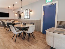 A dining area with round and rectangular tables with chairs a blue door and wall mirrors at Number 2 Dome in Derrybeg County Donegal