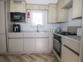 A kitchen with built in oven stove microwave and cabinets at HW42 in Bognor Regis
