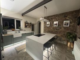 A kitchen with a central island and sink at Yew Tree Cottage in Mealsgate near Ireby