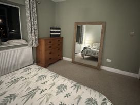 A bedroom with a bed and dresser at Yew Tree Cottage in Mealsgate near Ireby