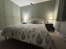 A bedroom with a bed and wardrobe at Yew Tree Cottage Mealsgate near Ireby