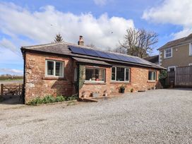 A house with solar panels and gravel driveway at Yew Tree Cottage Mealsgate near Ireby