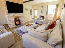 A living room with a sofa and fireplace at Yew Tree Cottage Mealsgate near Ireby