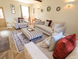 A living room with sofas and a coffee table at Yew Tree Cottage Mealsgate near Ireby