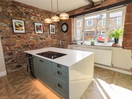 A kitchen with a stone wall and island at Yew Tree Cottage Mealsgate near Ireby