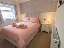 A bedroom with a bed and bedside table at Yew Tree Cottage Mealsgate near Ireby