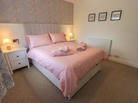 A bedroom with a bed and bedside table at Yew Tree Cottage Mealsgate near Ireby