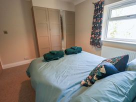 A bedroom with a bed and wardrobe at Yew Tree Cottage Mealsgate near Ireby