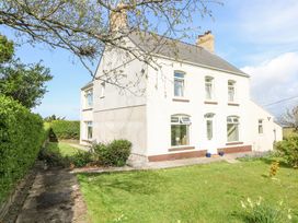 A two story house with a garden and pathway surrounded by hedges at Burry House in Llanmorlais