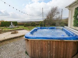 An outdoor area with a hot tub and seating at Burry House Llanmorlais
