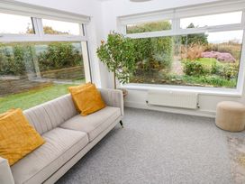 A conservatory with a sofa and a plant at Burry House Llanmorlais
