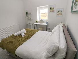 A bedroom with a bed and desk at Burry House Llanmorlais