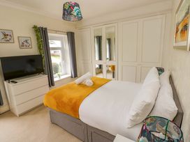 A bedroom with a bed and television at Burry House Llanmorlais