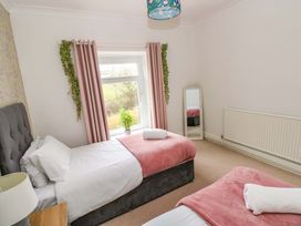 A bedroom with two beds and a window at Burry House in Llanmorlais