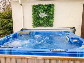A hot tub with water and greenery background at Burry House in Llanmorlais