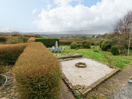 A garden with a gravel area and seating at Burry House Llanmorlais