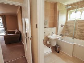 A bathroom with a bathtub, toilet, and sink at 3 Hawk Place, Moresby Parks near Whitehaven