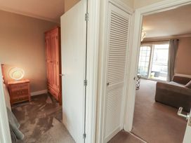 A hallway with a closet and lamp at 3 Hawk Place in Moresby Parks near Whitehaven
