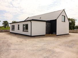 A house with a sloped roof and windows at Teach Ti in Miltown Malbay