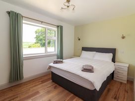 A bedroom with a bed and nightstand at Teach Ti in Miltown Malbay