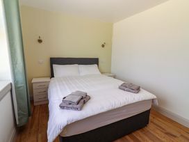 A bedroom with a bed and bedside table at Teach Ti in Miltown Malbay