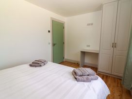 A bedroom with a bed and towels at Teach Ti in Miltown Malbay