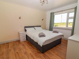 A bedroom with a bed and nightstand at Teach Ti in Miltown Malbay