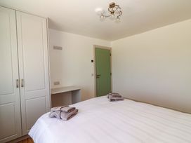 A bedroom with a bed and wardrobe at Teach Ti in Miltown Malbay