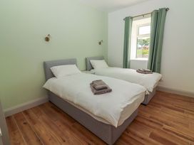 A bedroom with two single beds and a window at Teach Ti in Miltown Malbay