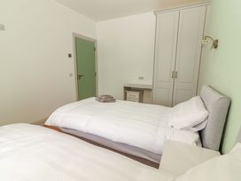A bedroom with two beds and a wardrobe at Teach Ti in Miltown Malbay