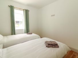 A bedroom with two beds and towels at Teach Ti in Miltown Malbay