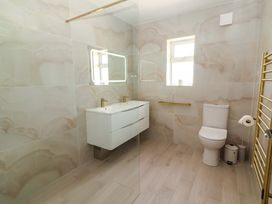 A bathroom with a sink, mirror, and toilet at Teach Ti in Miltown Malbay