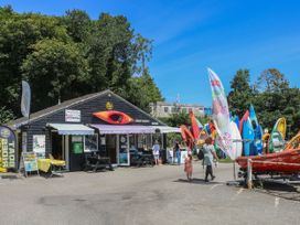 An outdoor area with a building rental kayaks and people at 5 Esplanade in Fowey