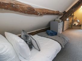 A bedroom with a bed pillows and towels under exposed wooden beams at Penyrgrisiau in Barmouth