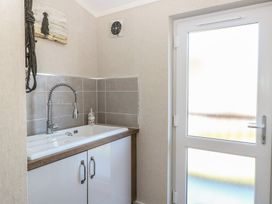 A laundry room with a sink and cabinet at Life's a Beach in Bacton