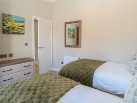 A bedroom with two beds and a painting at Life's a Beach in Bacton
