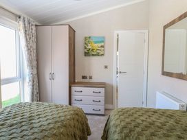 A bedroom with a wardrobe and a chest of drawers at Life's a Beach in Bacton