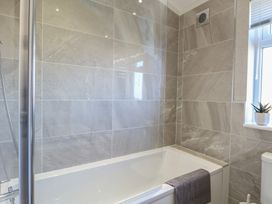 A bathroom with a bathtub and shower at Life's a Beach Bacton