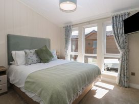 A bedroom with a bed and window at Life's a Beach in Bacton