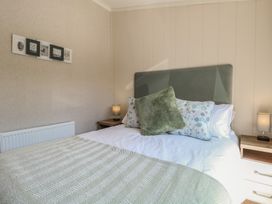 A bedroom with a bed and wall art at Life's a Beach in Bacton