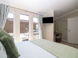 A bedroom with a bed and desk at Life's a Beach in Bacton