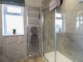 A bathroom with a shower and towel rail at Life's a Beach in Bacton
