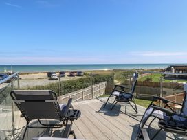 An outdoor area with chairs overlooking the sea at Life's a Beach in Bacton