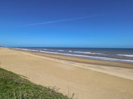 A beach with sand and ocean waves at Life's a Beach in Bacton