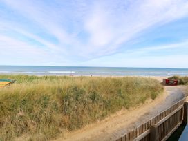 A beach view with sand and grass at Life's a Beach in Bacton